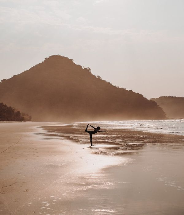Woman in a graceful yoga pose in nature at sunrise.